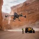 A drone team flying a DJI Matrice 400 in a canyon with a Zenmuse P1