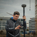 A surveyor using the Emlid RS4 Pro GNSS receiver at a construction project ste
