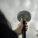 Closeup of hand holding the Emlid RS4 Pro on a survey pole
