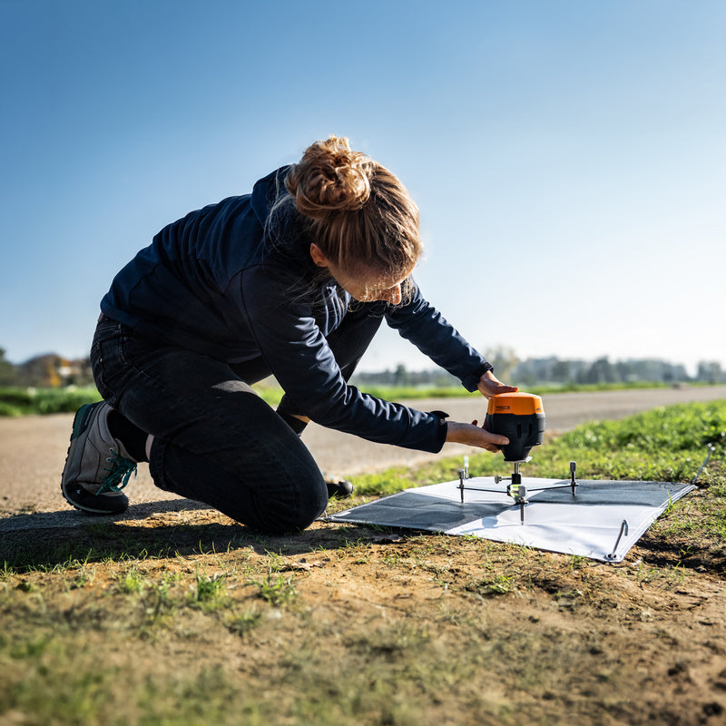A female surveyor sets up WingtraGROUND on a Ground Control Point