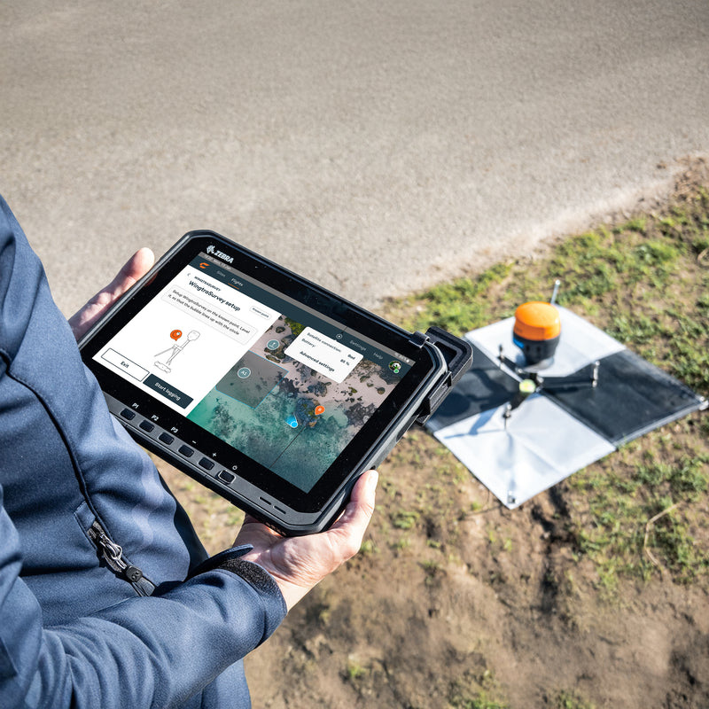 A surveyor configuring and setting up the WingtraGROUND receiver in a quarry