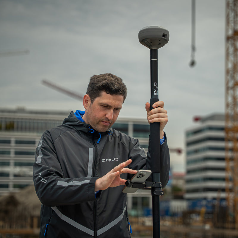 A surveyor using the Emlid RS4 Pro GNSS receiver at a construction project ste