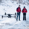 Two search and rescue responders flying the DJI Matrice 30T thermal drone in a snowy winter area.