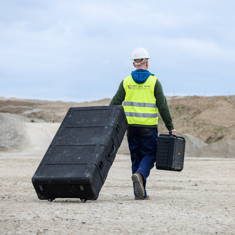 Drone Pilot wheeling hard case for WingtraRAY in an aggregate mine