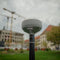 Emlid RS4 GNSS receiver on a survey pole in front of a construction project site